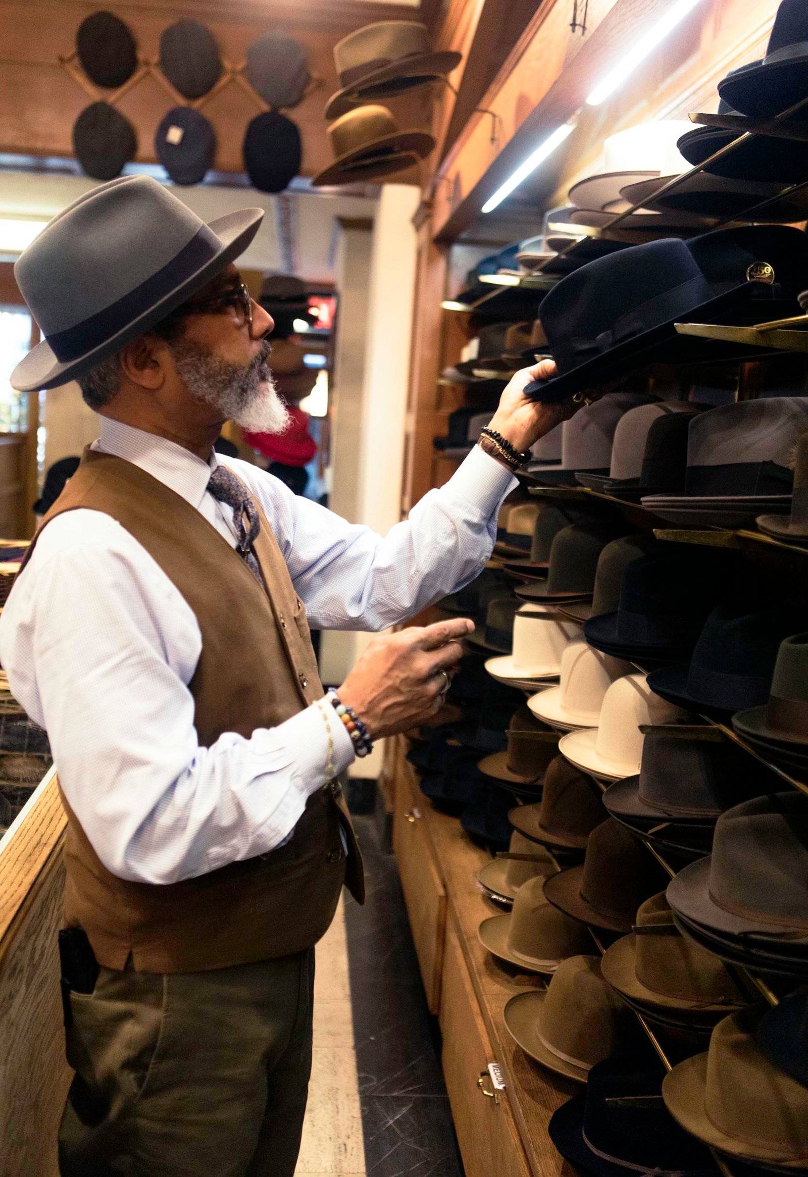 Man Picking Hats in Rack